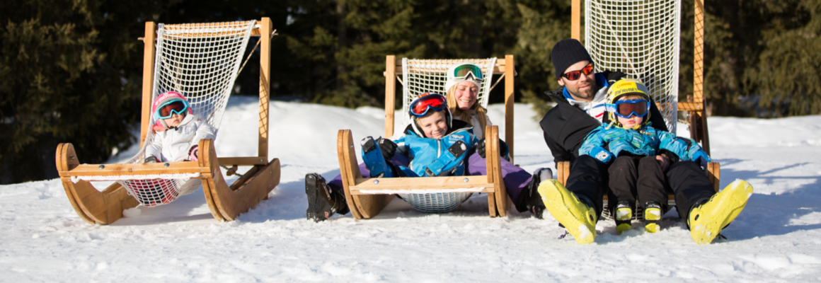 Une famille est installée sur des transats au bord des pistes de ski.