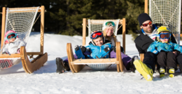 Une famille est installée sur des transats au bord des pistes de ski.