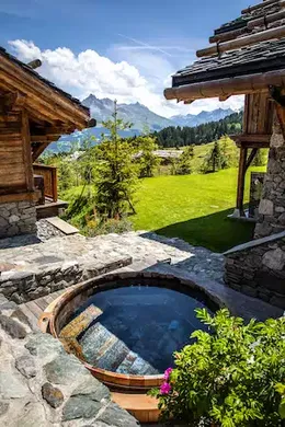 Bain nordique extérieur entre deux chalets , avec une vue sur la vallée.