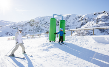 Une maman skie avec son enfant débutant sur une piste verte de Méribel.