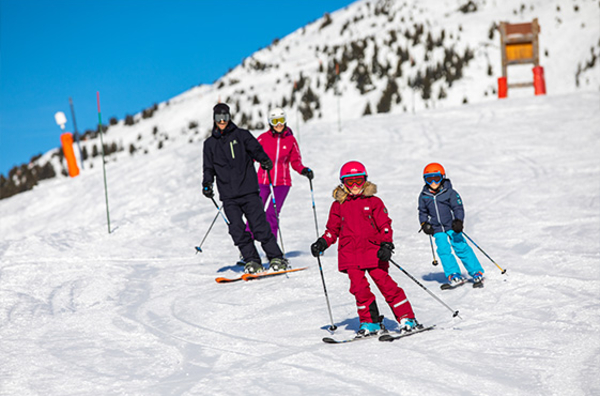 Famille en train de skier sur une piste facile du domaine