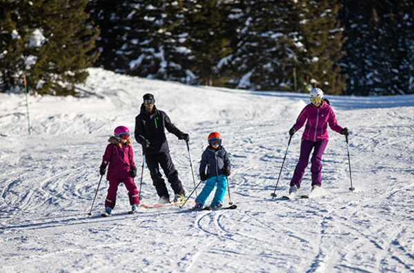 Famille en trian de skier sur un piste verte